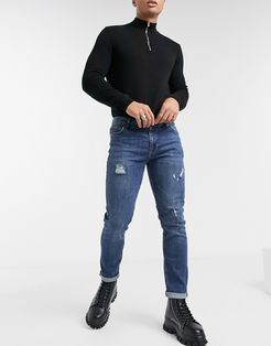 skinny jeans in dark blue green cast wash with abrasions