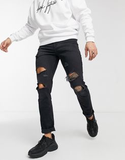 stretch slim jeans with 'less thirsty' wash in black with heavy rips