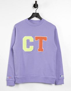 coordinating oversized sweatshirt with varsity design in washed purple
