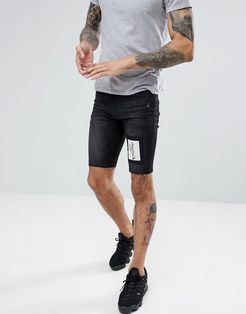 skinny fit denim shorts in black with skeleton patch