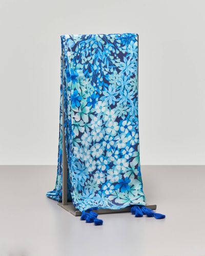 "Foulard a base blu e stampa floreale azzurra con nappe applicate ai lati"