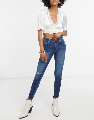skinny push up jean with knee rip in dark blue wash